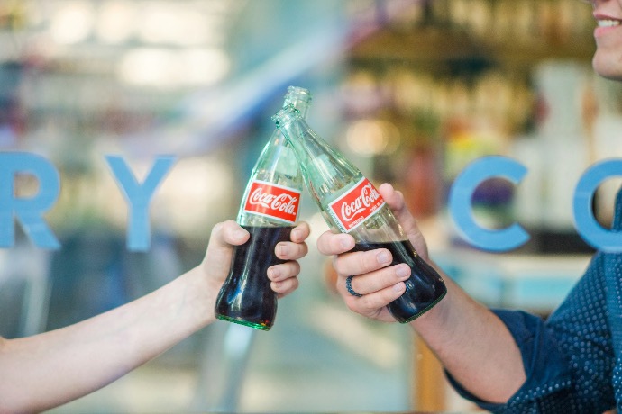 person holding Coca-Cola bottle at Twelve2 Marketing